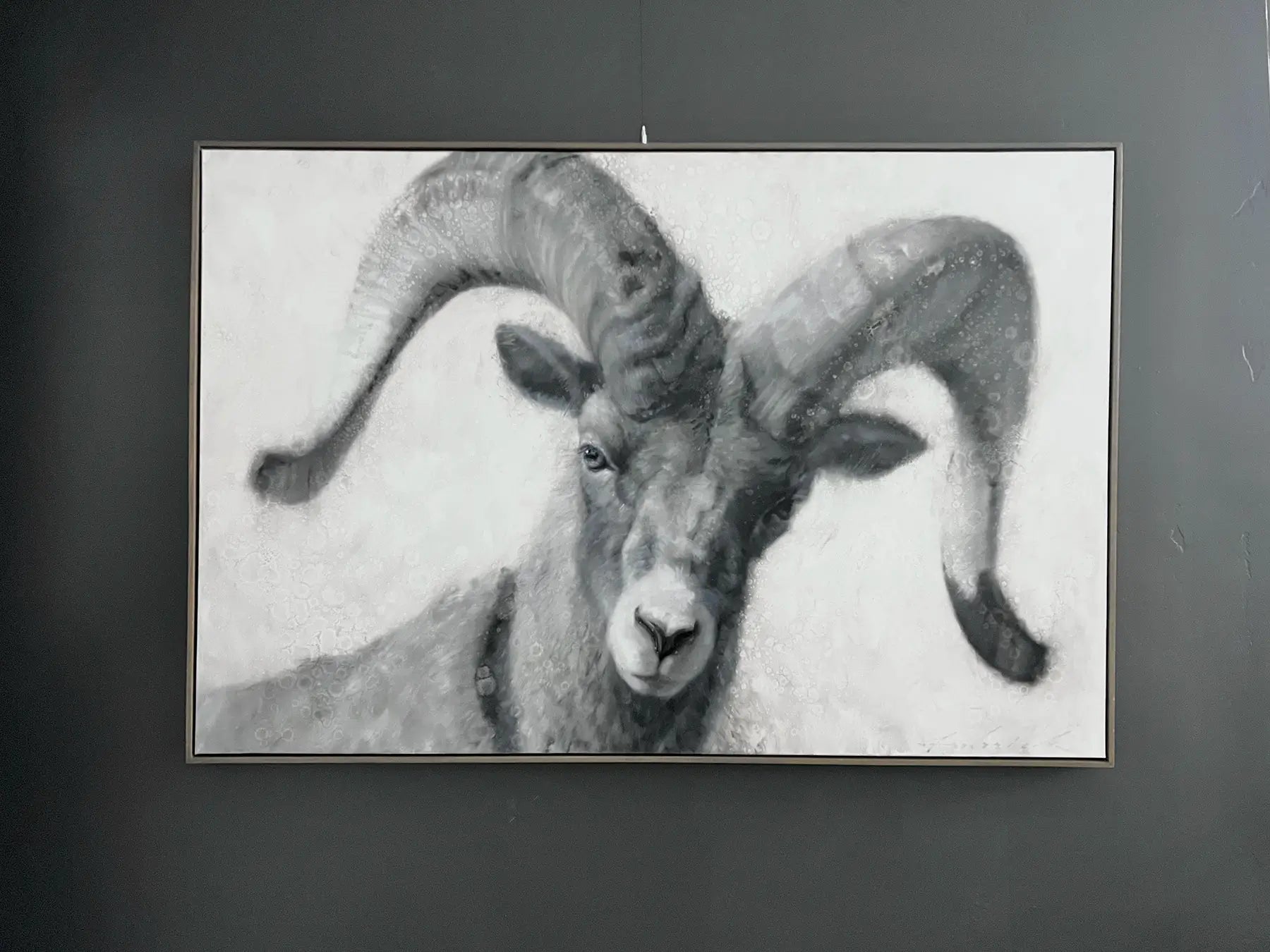 Framed artwork of a ram with large curved horns on a dark background